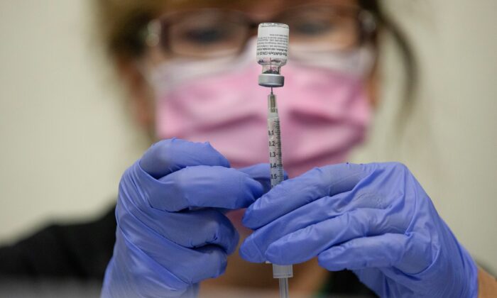 2021 年 9 月 29 日，一名护士在密歇根州绍斯菲尔德准备 COVID-19 疫苗。（Emily Elconin/路透社）