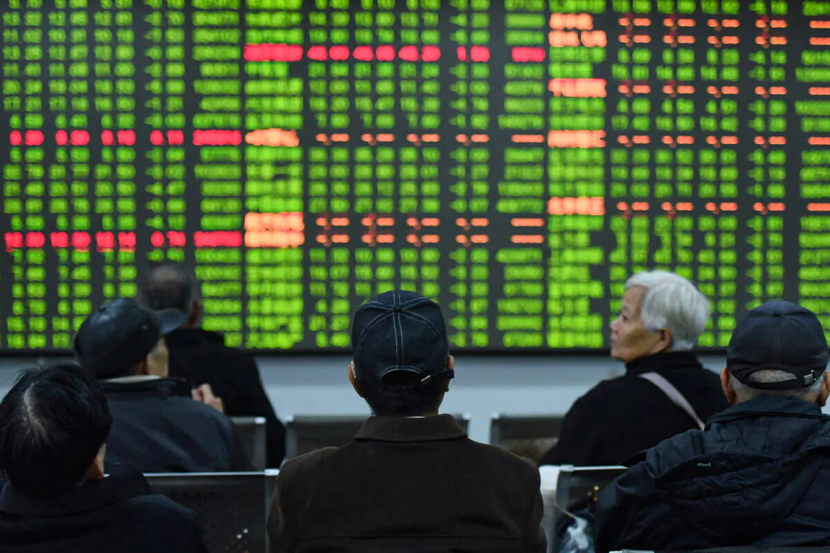 Investors sit in front of a board showing stock information at a brokerage house in Hangzhou, Zhejiang province, China, on Feb. 3, 2020. (China Daily via Reuters)