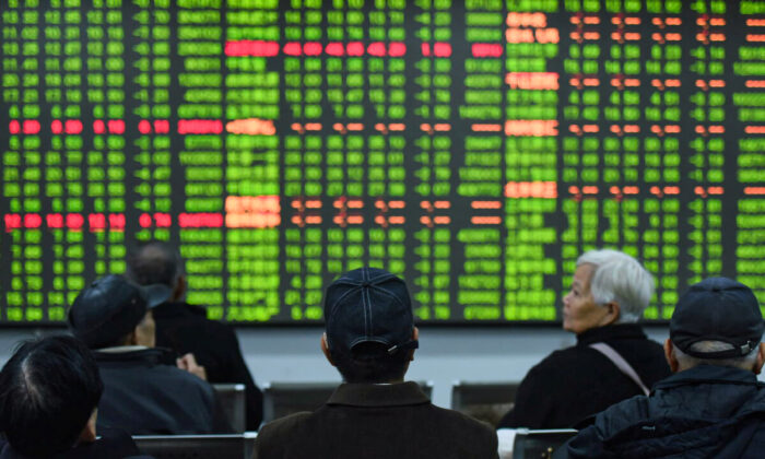 Investors sit in front of a board showing stock information at a brokerage house in Hangzhou, Zhejiang province, China, on Feb. 3, 2020. (China Daily via Reuters)