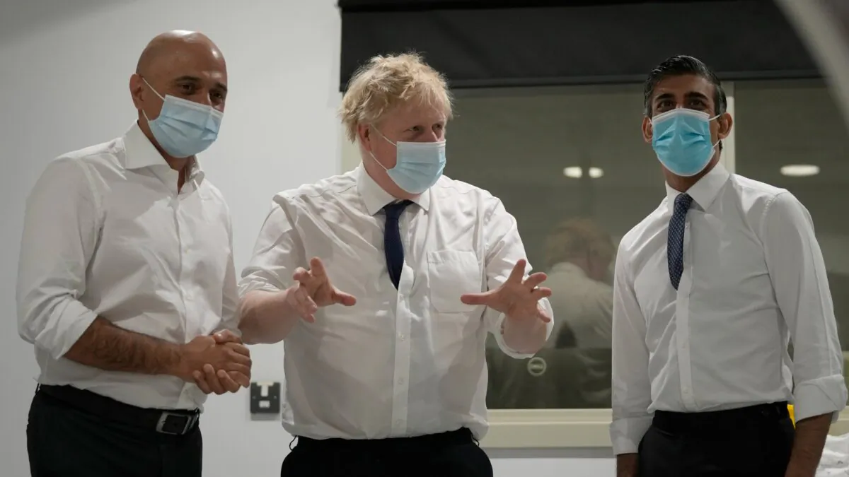Britain's Prime Minister Boris Johnson (C), Health Secretary Sajid Javid (L), and Chancellor of the Exchequer Rishi Sunak speak together as they look at a CT scanner during a visit to the New Queen Elizabeth II Hospital in Welwyn Garden City, England, on April 6, 2022. (Frank Augstein -WPA Pool/Getty Images)