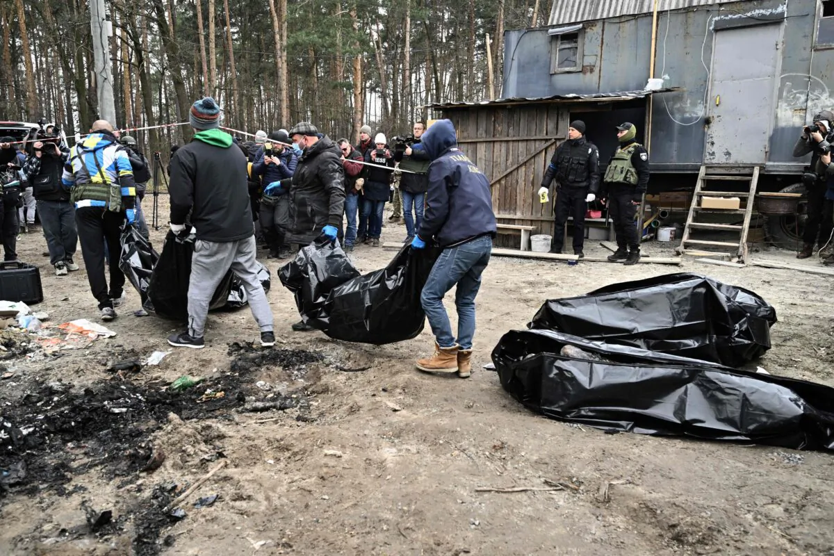 City workers carry body bags with six partially burnt bodies found in the town of Bucha, Ukraine, on April 5, 2022. (Genya Savilov/AFP via Getty Images)