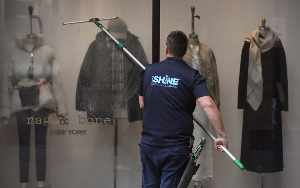 A window cleaner works on a shop front in Melbourne's central business district in Melbourne, Australia, on May 11, 2021. (William West/AFP via Getty Images)