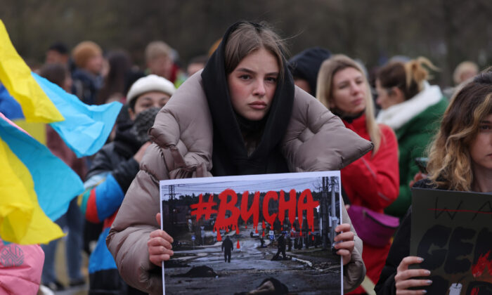 A protester holds up a photograph showing murdered civilians of the Ukrainian town of Bucha near Kyiv during a demonstration against the Russian military invasion of Ukraine in Berlin, Germany, on April 6, 2022. (Sean Gallup/Getty Images)