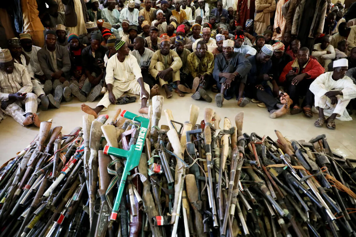 Members of the Yansakai vigilante group sit inside an auditorium at the Zamfara state government house as their members surrendered more than 500 guns to the governor Bello Matawalle, as part of efforts to accept the peace process of the state government in Gusau, on December 3, 2019. (Kola Sulaimon/ AFP via Getty Images)