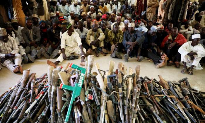 Members of the Yansakai vigilante group sit inside an auditorium at the Zamfara state government house as their members surrendered more than 500 guns to the governor Bello Matawalle, as part of efforts to accept the peace process of the state government in Gusau, on December 3, 2019. (Kola Sulaimon/ AFP via Getty Images)