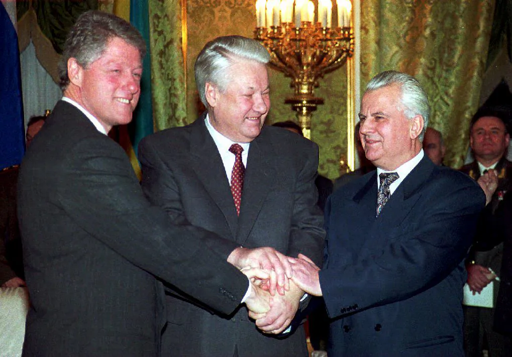 U.S. President Bill Clinton (L), Russian President Boris Yeltsin (C) and Ukrainian counterpart Leonid M. Kravchuk (R) join hands after signing a nuclear disarmament agreement in the Kremlin, Russia, on Jan. 14, 1994. (Sergei Supinsky/AFP via Getty Images)