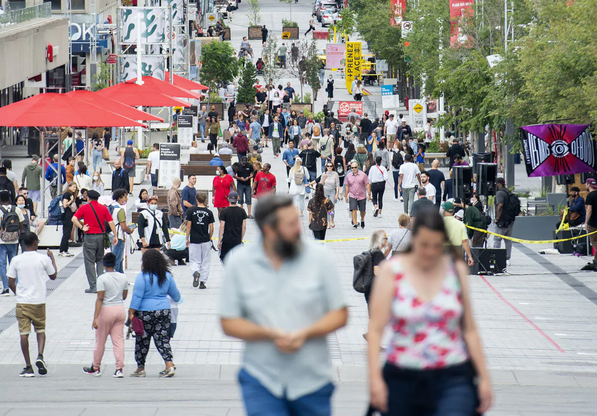 People walk along a street in Montreal on July 31, 2021. (The Canadian Press/Graham Hughes)