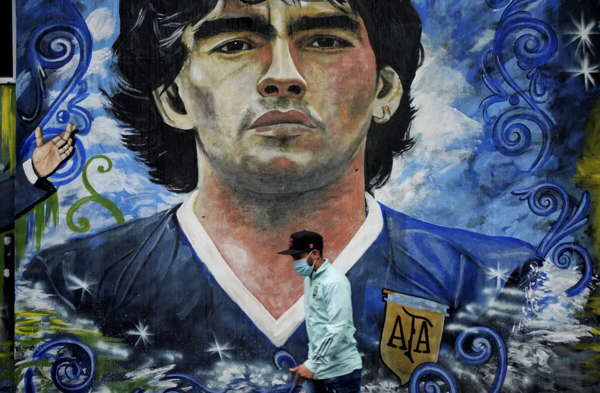 A pedestrian walks past a mural depicting late soccer legend Diego Armando Maradona in La Boca, Buenos Aires, Argentina, on Nov. 25, 2021. (Mariana Nedelcu/Reuters)