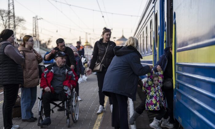 People embark a train in Odesa, southern Ukraine, on March 23, 2022. (Petros Giannakouris/AP Photo)