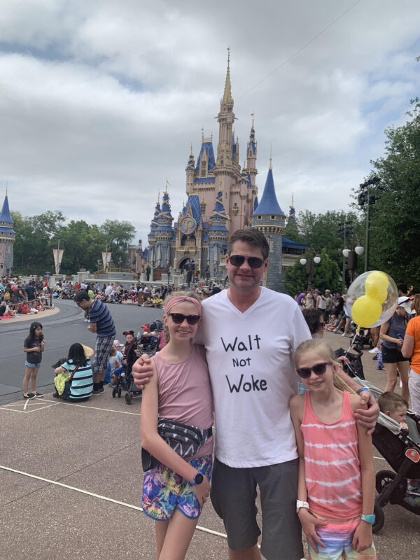 Dan Geffers poses for a photo with daughters Lila (Left, aged 13) and Bryn (age 11, on the right) in front of Cinderella's Castle at Disney's Magic Kingdom in Orlando, Florida.