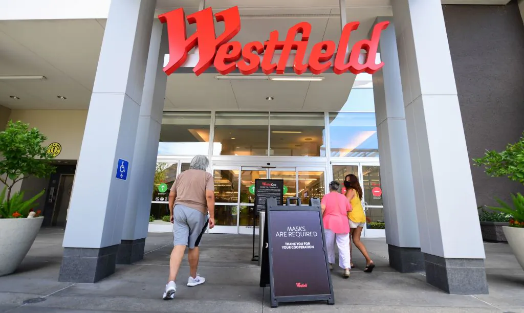 People walk past a sign reminding shoppers of the mask requirement while entering the Westfield Santa Anita shopping mall in Arcadia, Calif., on June 12, 2020. (Frederic J. Brown/AFP via Getty Images)