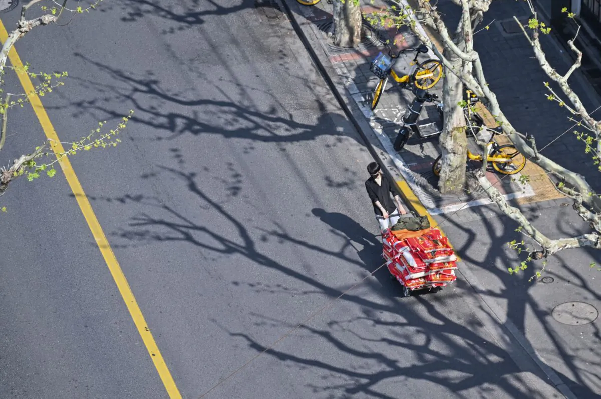A man pulls a cart on a street during a COVID-19 lockdown in the Jing'an district in Shanghai on April 8, 2022. (Hector Retamal/AFP via Getty Images)