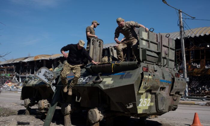 2022 年 4 月 7 日，乌克兰军人在乌克兰布查修理一辆装甲运兵车。（Anastasia Vlasova/Getty Images）
