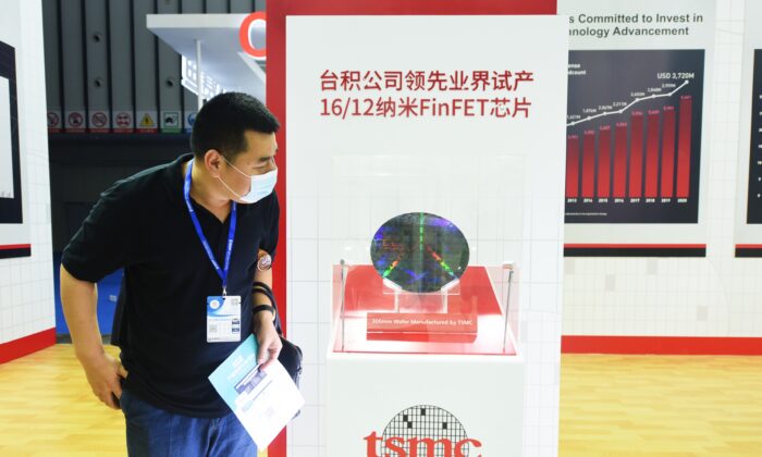 A visitor looks at a 300mm wafer at the booth of Taiwan Semiconductor Manufacturing Company Limited (TSMC) during the 2021 World Semiconductor Conference in Nanjing, Jiangsu Province, China, on June 9, 2021. (Long Wei/VCG via Getty Images)