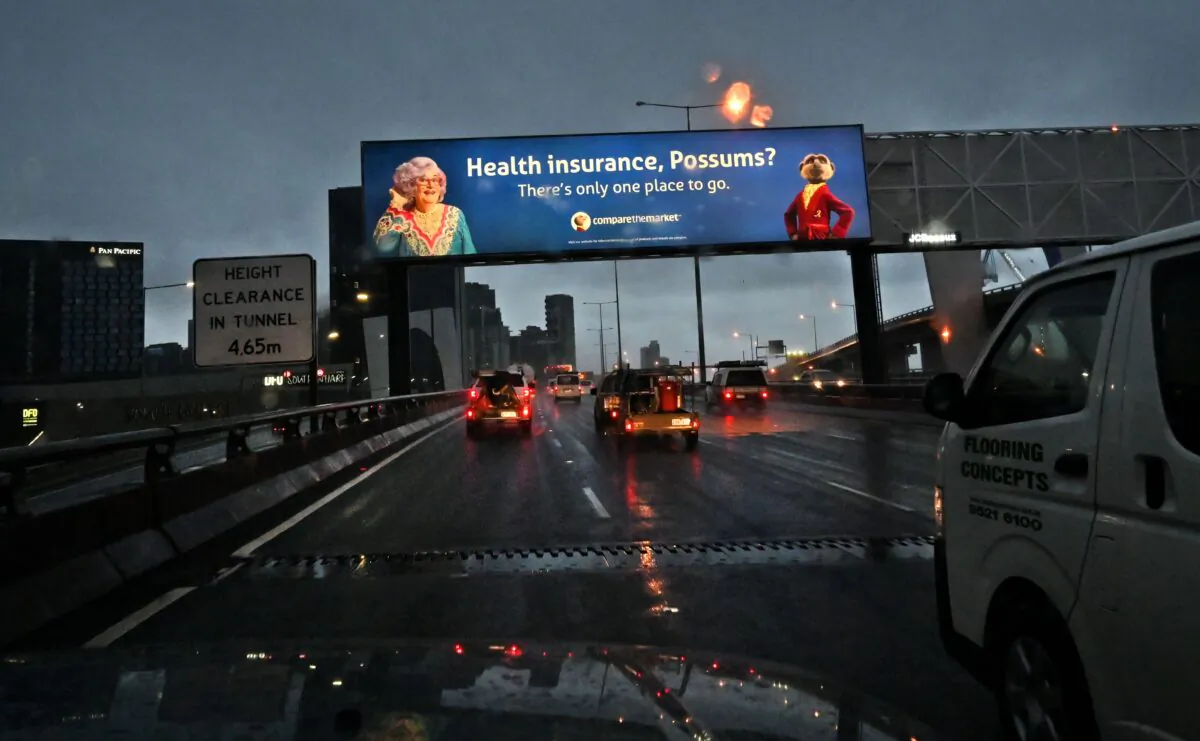 Commuters drive under a health insurance billboard in the wet weather at they head towards the Melbourne city centre, in Melbourne, Australia, on May 21, 2020. (William West/AFP via Getty Images)