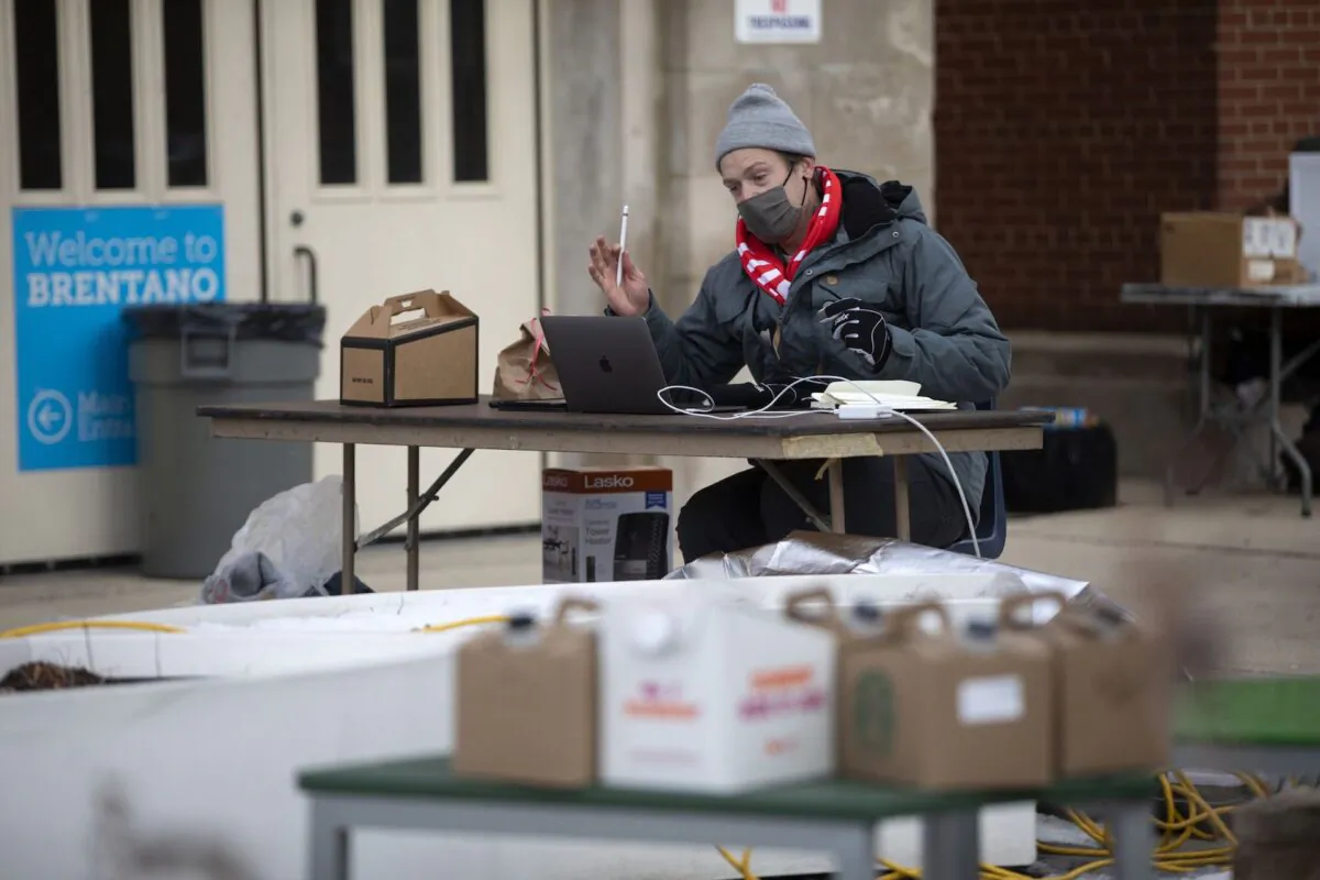 Middle school math teacher Aaron Bingea teaches remotely as he works outside Brentano Math & Science Academy in protest of Chicago Public Schools' reopening of in-person classes, on Jan. 4, 2021. (Erin Hooley/Chicago Tribune/TNS)