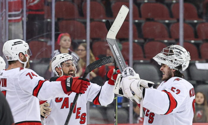 Carolina Hurricanes goaltender Pyotr Kochetkov (52) celebrates with defenseman Jaccob Slavin (74) and center Vincent Trocheck (16) after an overtime victory against the New Jersey Devils at Prudential Center, in Newark, N.J., on April 23, 2022. (Vincent Carchietta/USA TODAY Sports via Field Level Media)