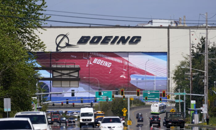 Traffic drives in view of a massive Boeing Co. production plant, where images of jets decorate the hangar doors, Friday in Everett, Wash., on April 23, 2021. (Elaine Thompson/AP Photo)