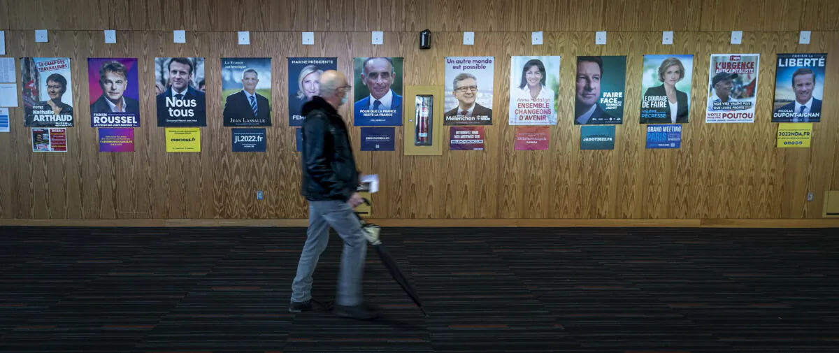 A French voter passes identification posters on his way to vote in the first round of the 2022 French presidential election in Montreal on April 9, 2022. (Peter McCabe/The Canadian Press via AP)