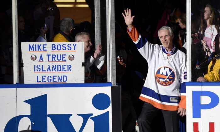 Hockey Hall of Famer and former New York Islander Mike Bossy waves to fans as he is introduced before the NHL hockey game between the Islanders and the Boston Bruins at Nassau Coliseum in Uniondale, N.Y., on Jan. 29, 2015. (Kathy Kmonicek/AP Photo)