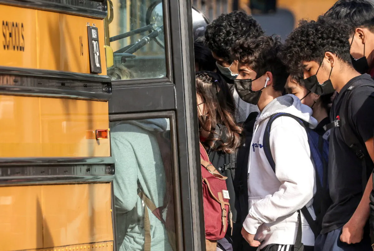 Students board a school bus outside of Washington-Liberty High School in Arlington County which is one of several school districts which sued to stop the mask-optional order by Governor Glenn Youngkin (R), in Arlington, Va., on Jan. 25, 2022. (Evelyn Hockstein/Reuters)
