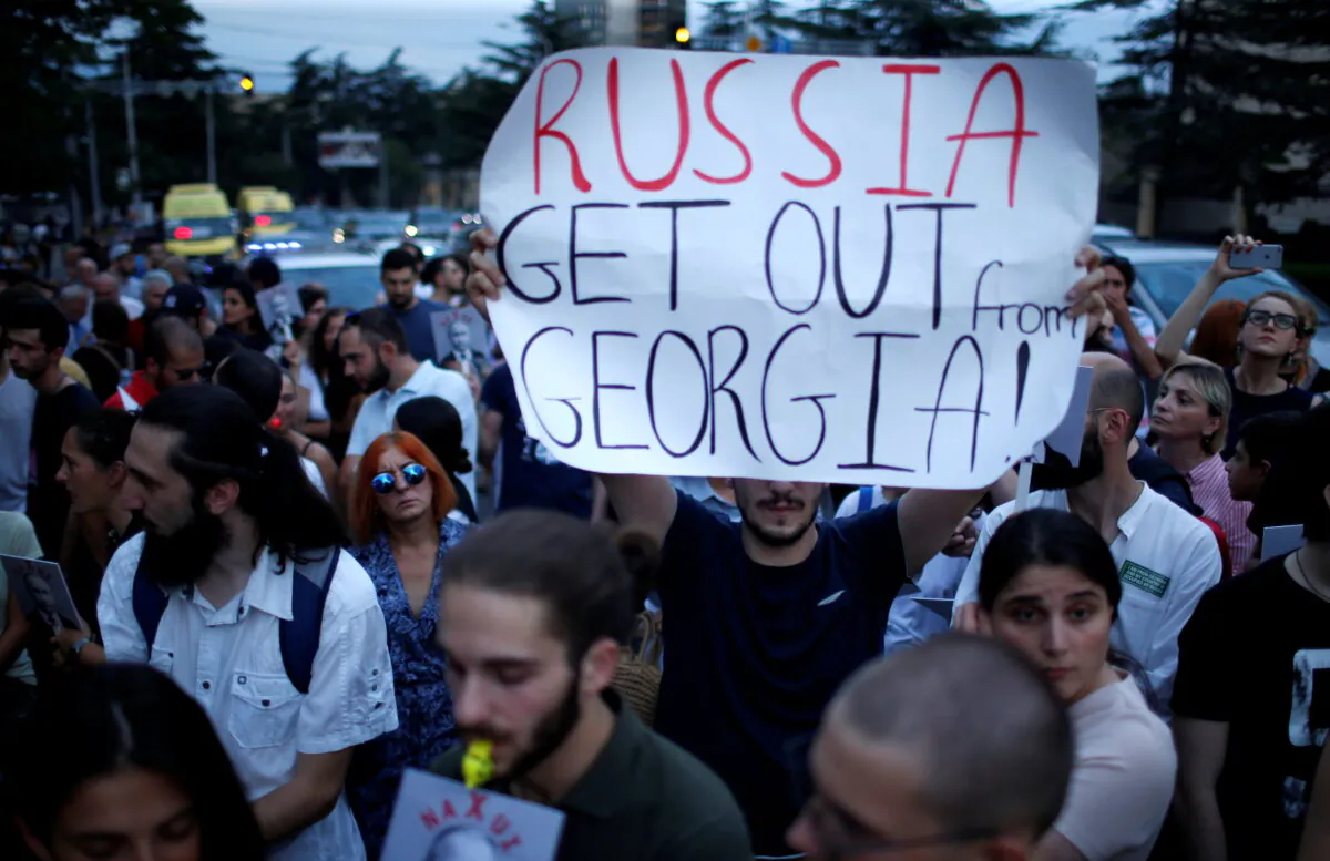 People attend a protest on the 10th anniversary of Georgian-Russian war in front of the building of Russian Federation Interests Section of the Embassy of Switzerland in Tbilisi, Georgia, Aug. 7, 2018. (David Mdzinarishvili/Reuters)