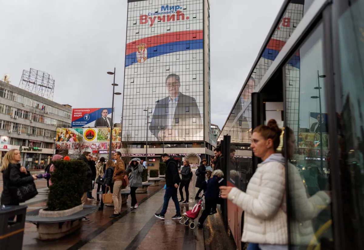 People walk by a huge election campaign billboard featuring Aleksandar Vucic, the presidential candidate of the ruling Serbian Progressive Party (SNS), in Nis, Serbia, on April 1, 2022. (Reuters/Antonio Bronic)