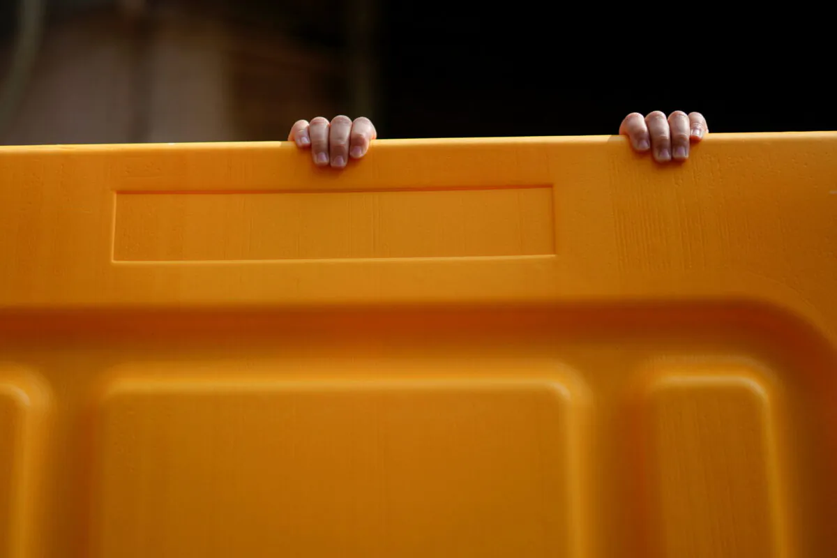 A child's hands on a barrier at an area under lockdown amid the coronavirus disease (COVID-19) pandemic, in Shanghai, China on March 26, 2022. (Aly Song/Reuters)