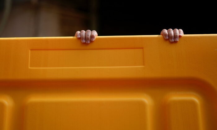 A child's hands on a barrier at an area under lockdown amid the coronavirus disease (COVID-19) pandemic, in Shanghai, China on March 26, 2022. (Aly Song/Reuters)
