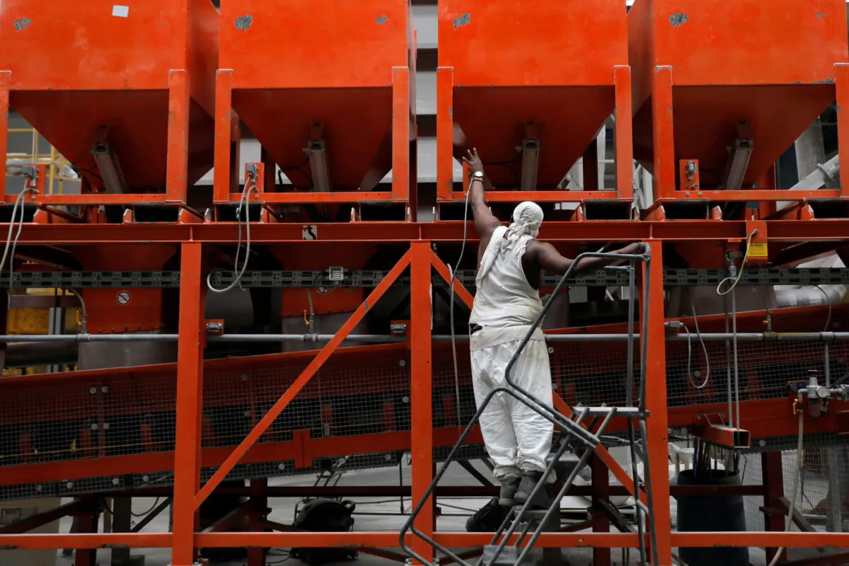 A worker checks equipment in the factory at IceStone, a manufacturer of recycled glass countertops and surfaces, in New York City, New York, U.S., June 3, 2021. REUTERS/Andrew Kelly