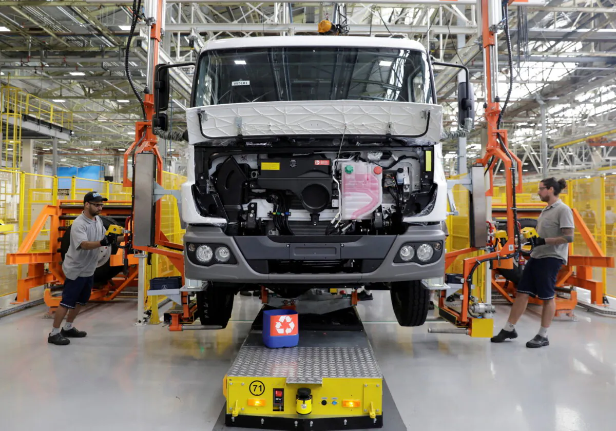 Employees work on the new assembly line to build trucks at Mercedes Benz's trucks and buses manufacturing plant in Sao Bernardo do Campo, Brazil, on March 27, 2018. (Paulo Whitaker/Reuters)