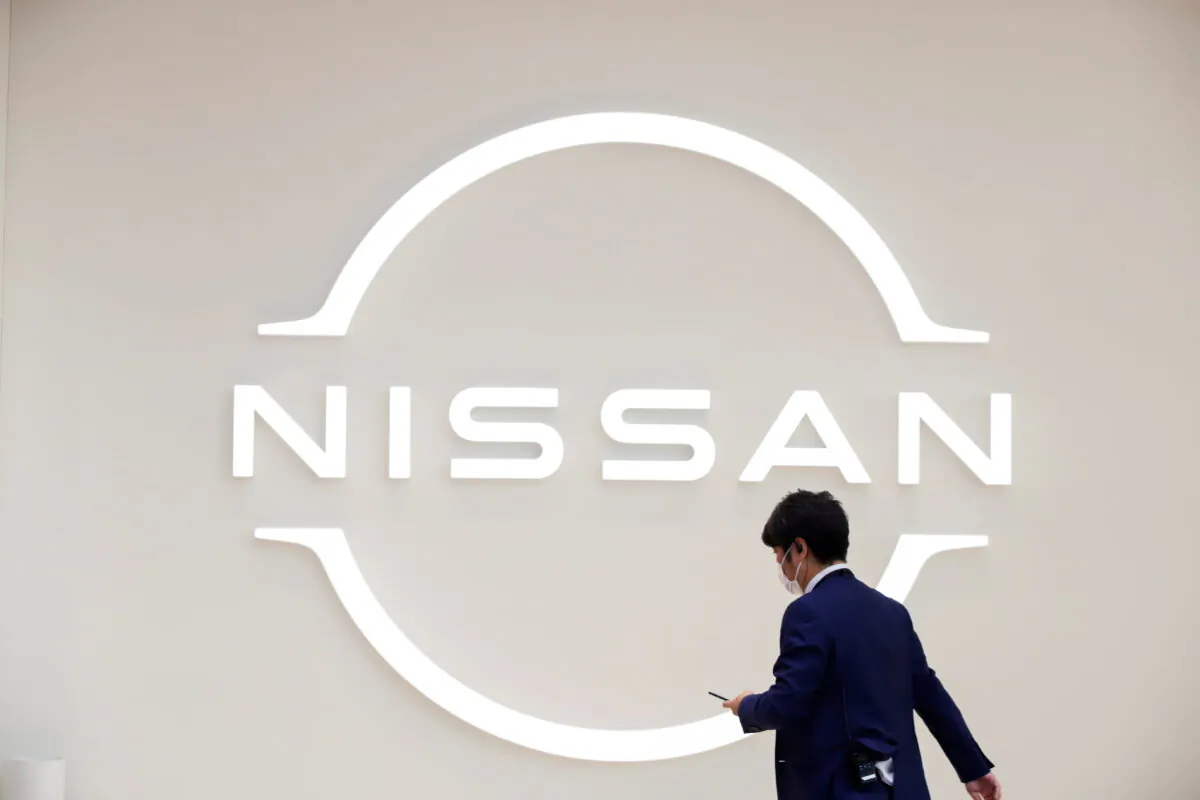 A man walks in front of the Nissan logo at Nissan Gallery in Yokohama, Japan on Nov. 29, 2021. (Androniki Christodoulou/Reuters)