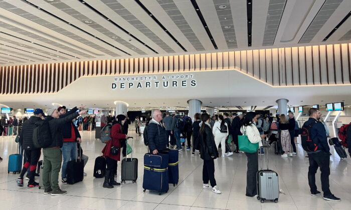 2022 年 4 月 4 日，乘客在英国曼彻斯特机场 2 号航站楼出发区排队接受安检。（Phil Noble/路透社）