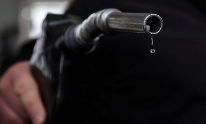 Gasoline drips out of a nozzle held by a gas station mechanic in Somerville, Massachusetts, on March 7, 2022. (Brian Snyder/Reuters)