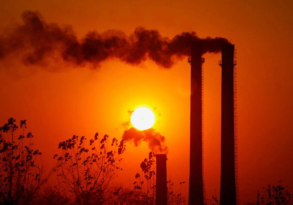 FILE PHOTO: Smoke spews from chimneys of an oil refinery in Nanjing, east China's Jiangsu province, December 28, 2006. REUTERS/Sean Yong