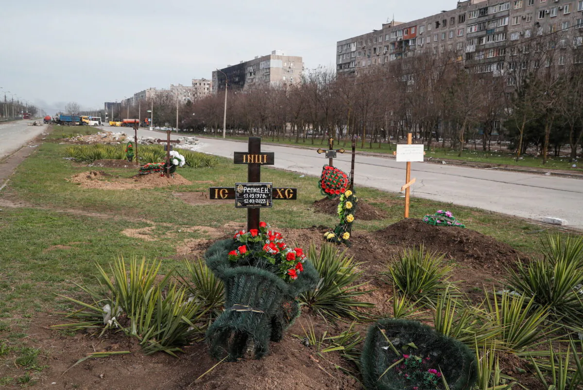 Graves of civilians killed during the Ukraine-Russia conflict are seen next to apartment buildings in the southern port city of Mariupol, Ukraine, on April 10, 2022. (Alexander Ermochenko/Reuters)