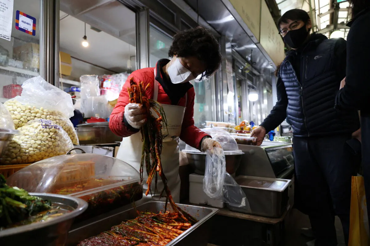 Choi Sun-Hwa sells a traditional Korean side dish kimchi at her side dish store at a traditional market in Seoul, South Korea, on April 7, 2022. (Kim Hong-Ji/Reuters)