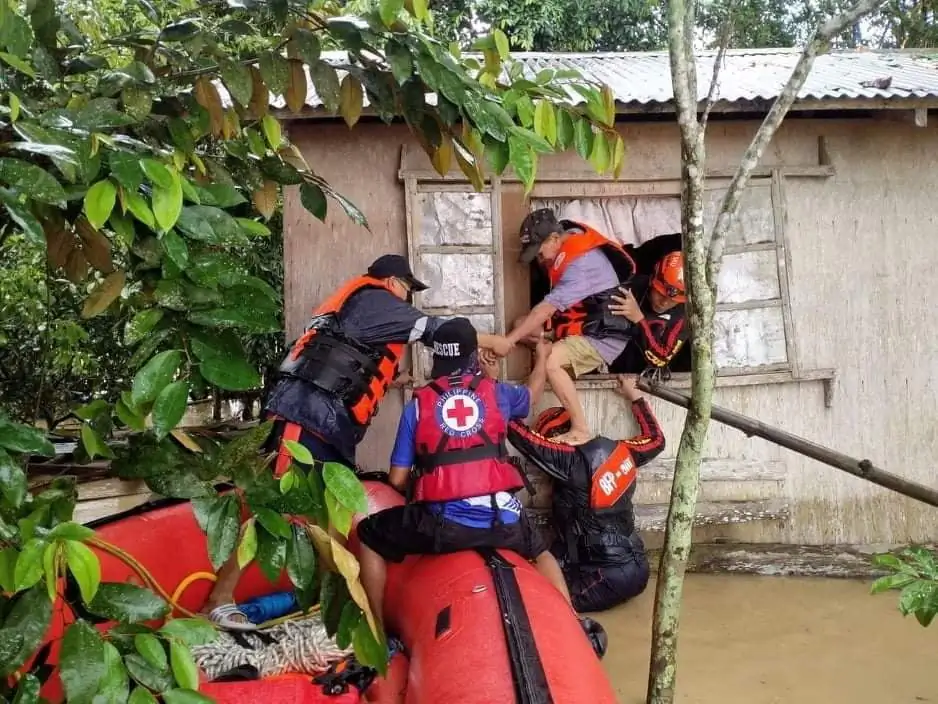 Rescue personnels assist a man onto a rescue boat after the tropical storm Megi hit, in Capiz Province, Philippines, on April 12, 2022. (Philippine Coast Guard/Handout via Reuters)