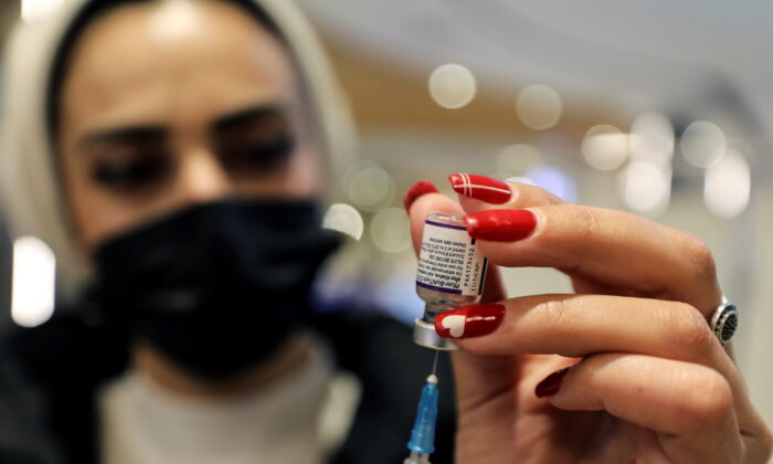 A health worker prepares a dose of Pfizer-BioNTech's COVID-19 vaccine in Malcha Mall, Jerusalem, December 22, 2021. (Ammar Awad/Reuters)
