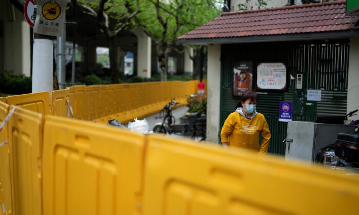 A resident behind barriers sealing off an area under lockdown in Shanghai on April 14, 2022. (Aly Song/Reuters)