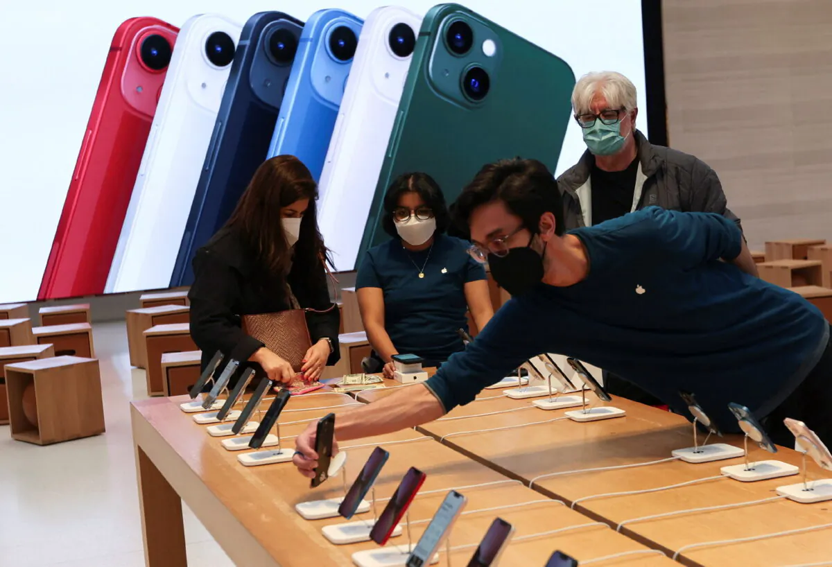 An employee arranges Apple iPhones as customer shop at the Apple Store on 5th Avenue shortly after new products went on sale in Manhattan, in New York City, on, March 18, 2022. (Mike Segar/Reuters)