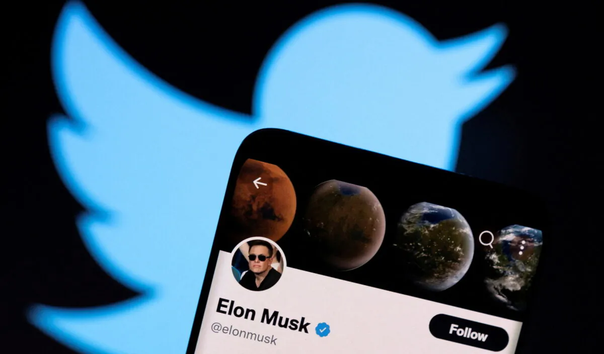 Elon Musk's Twitter account is seen on a smartphone in front of the Twitter logo in this photo illustration taken on April 15, 2022. (Dado Ruvic/Illustration/Reuters)