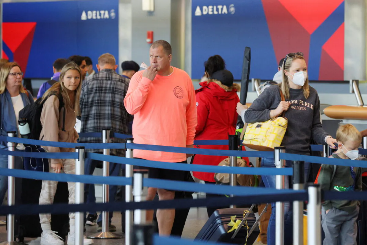 Travellers wait in line at a Delta Airlines counter at Logan International Airport in Boston on April 19, 2022. (Brian Snyder/Reuters)