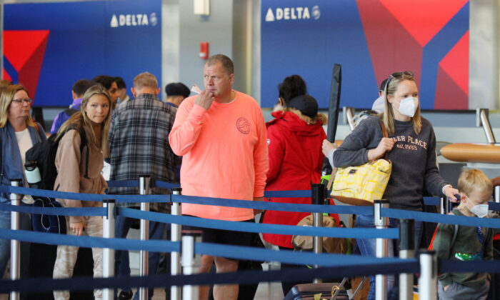 Travellers wait in line at a Delta Airlines counter at Logan International Airport in Boston on April 19, 2022. (Brian Snyder/Reuters)