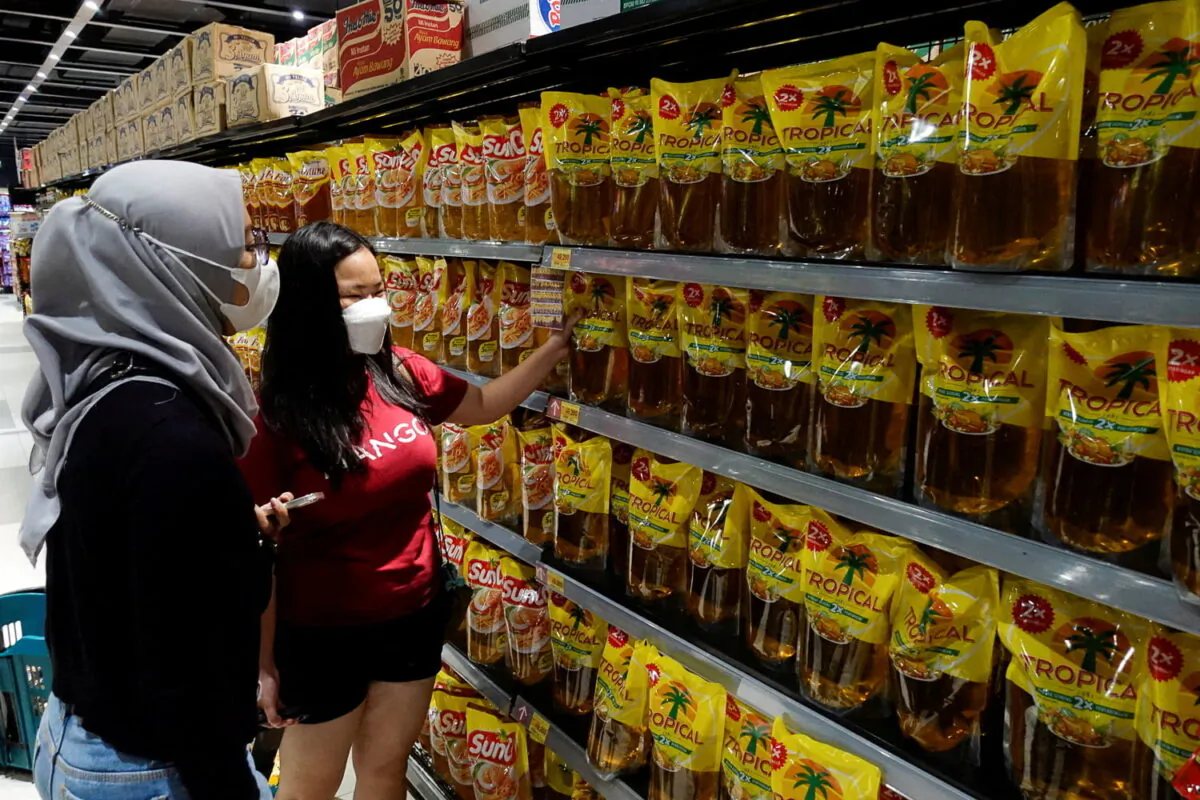 People shop for cooking oil made using palm oil at a supermarket in Jakarta, Indonesia, on March 27, 2022. (Willy Kurniawan/Reuters)