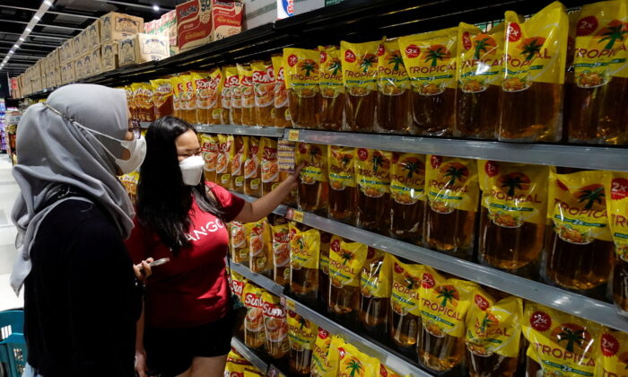 People shop for cooking oil made using palm oil at a supermarket in Jakarta, Indonesia, on March 27, 2022. (Willy Kurniawan/Reuters)