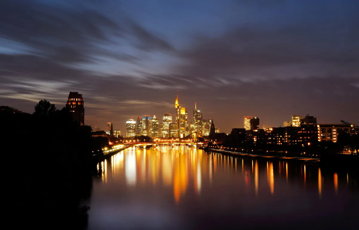 The sun sets behind the skyline with the banking district in Frankfurt, Germany, on Oct. 18, 2021. (Kai Pfaffenbach/Reuters)