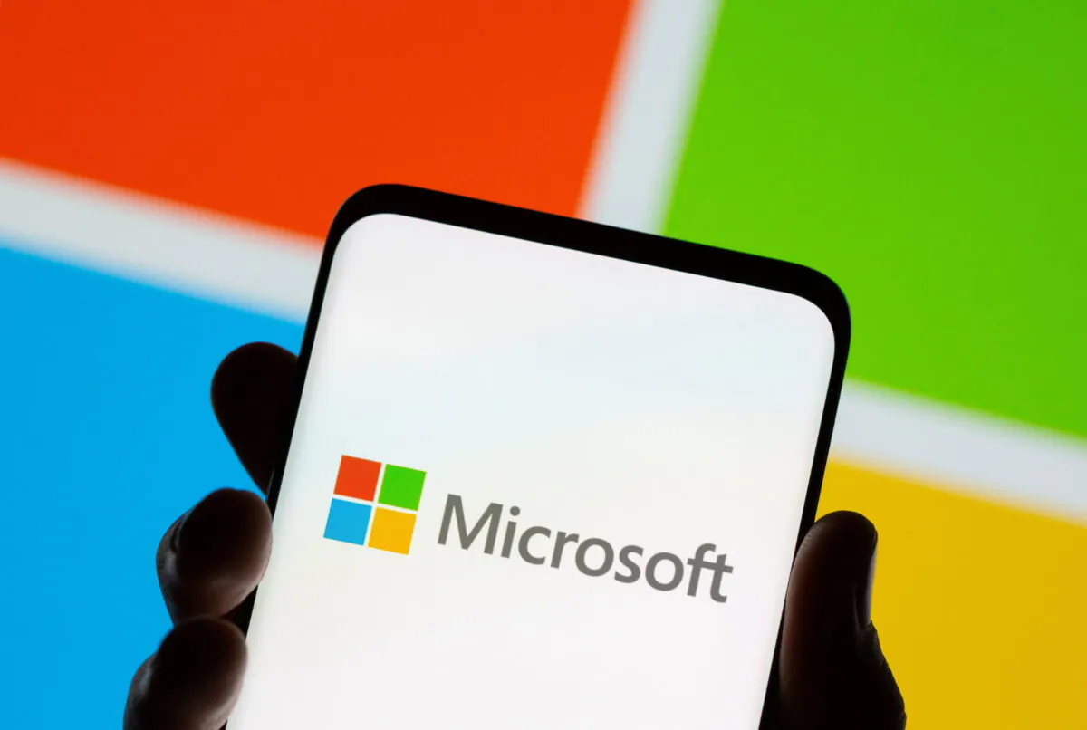 A smartphone in front of a Microsoft logo, on July 26, 2021. (Dado Ruvic/Illustration/Reuters)