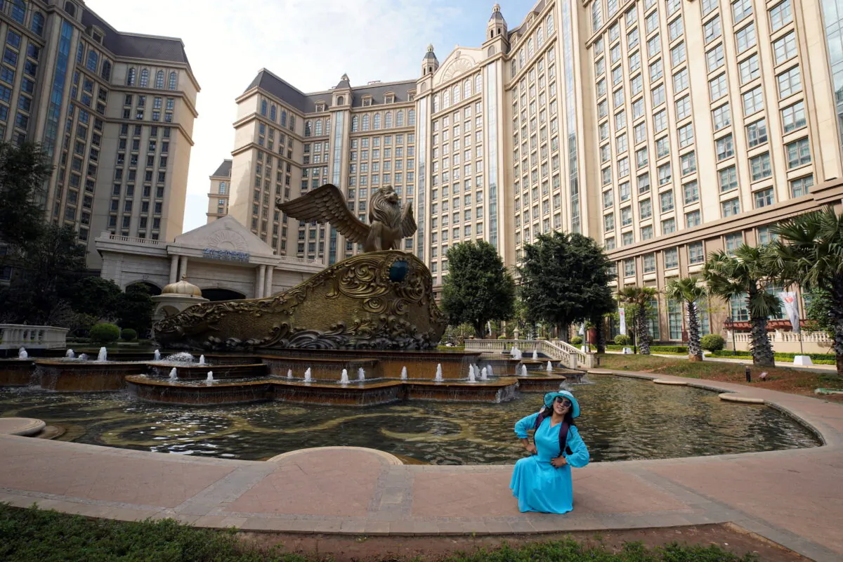 A visitor poses for pictures at Castle Hotel on the man-made Ocean Flower Island, an integrated resort development by China Evergrande Group, in Danzhou, Hainan province, China, on Jan. 7, 2022. (Aly Song/Reuters)