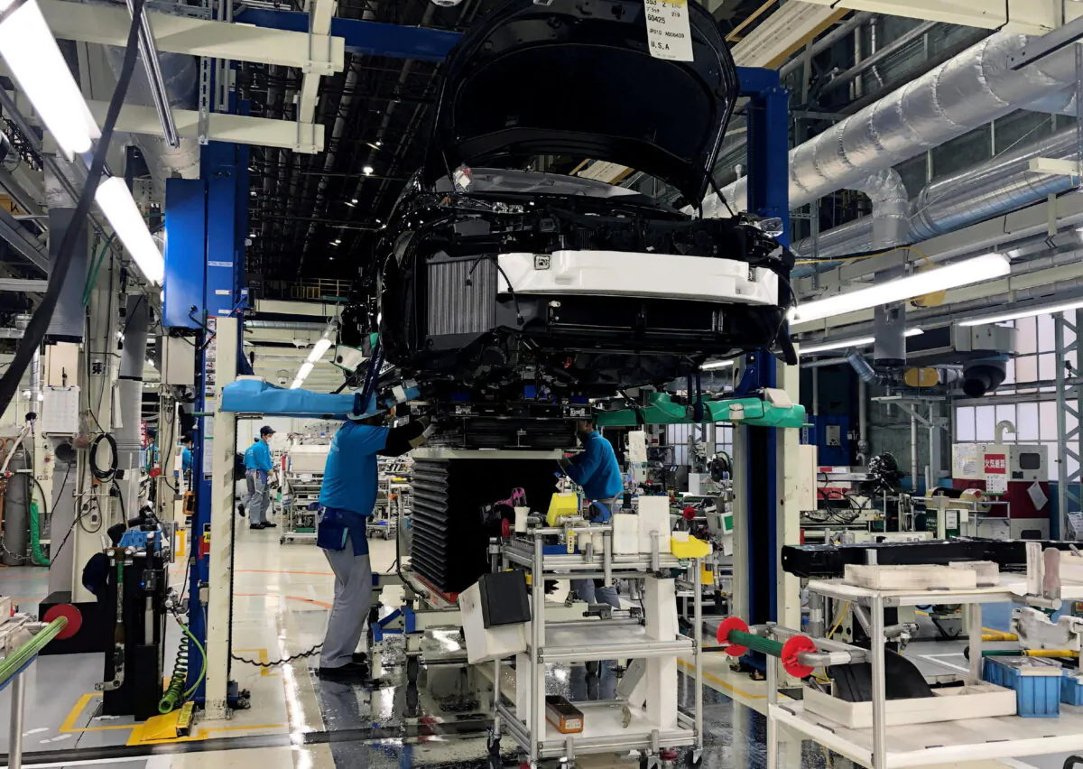 Workers install the fuel cell power system in a Toyota Mirai at a Toyota Motor Corp. factory in Aichi Prefecture, Japan, on April 11, 2019. (Joe White/Reuters)